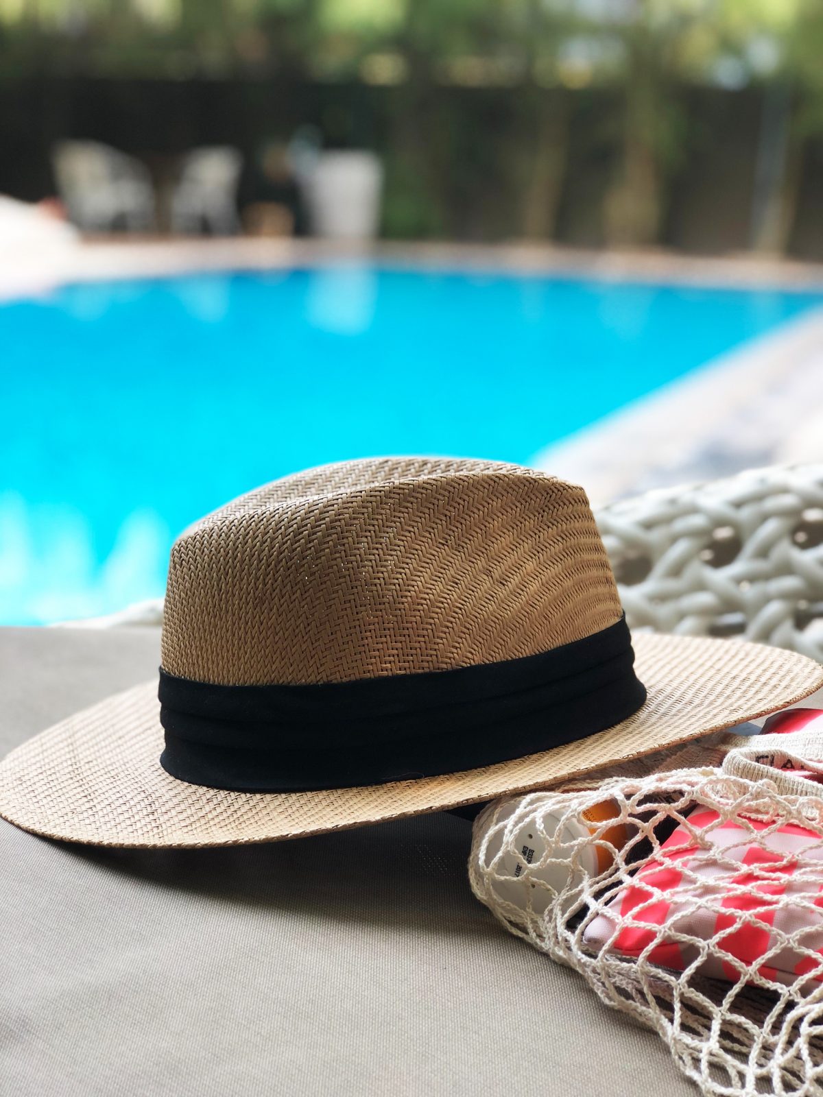 Solhat ved pool stemningsbillede